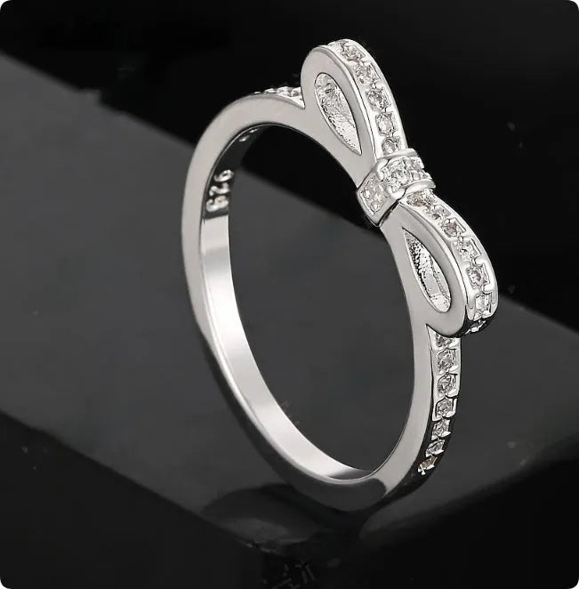 Silver bow-shaped ring with rhinestone zircon crystal decoration on model finger