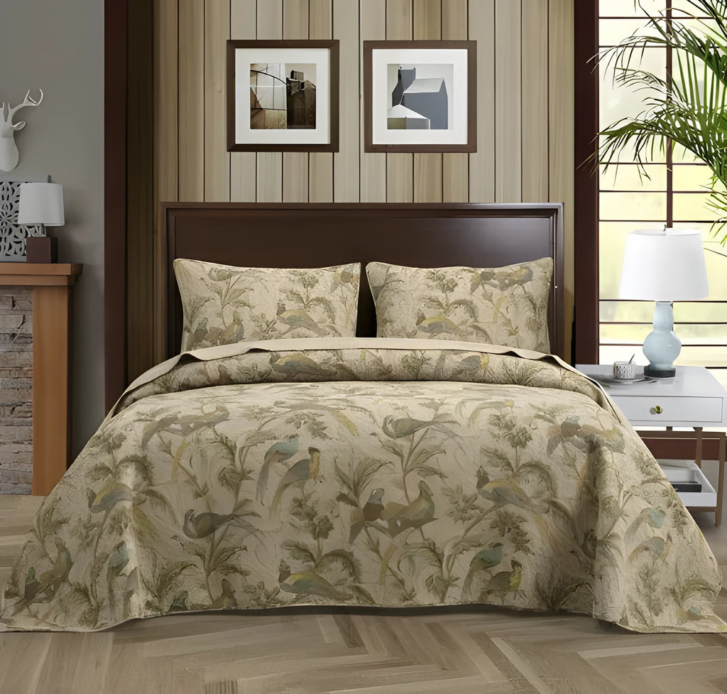 Blue botanical patterned quilted cotton bedspread set on a bed, showing plants, flowers, and bird design.