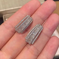 Geometric stud earrings with zircon stones in white gold colour on copper base