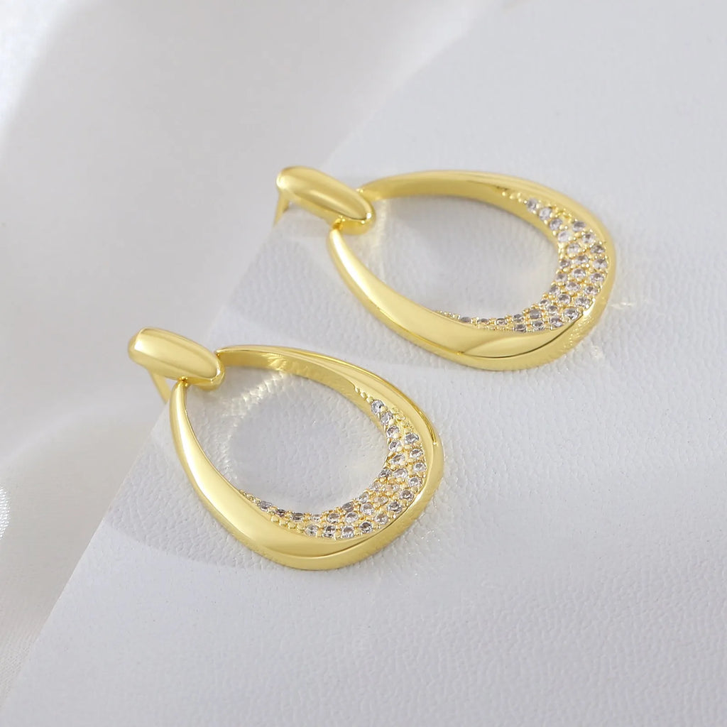 Yellow gold geometric drop-shaped women's earrings with round and oval design elements.