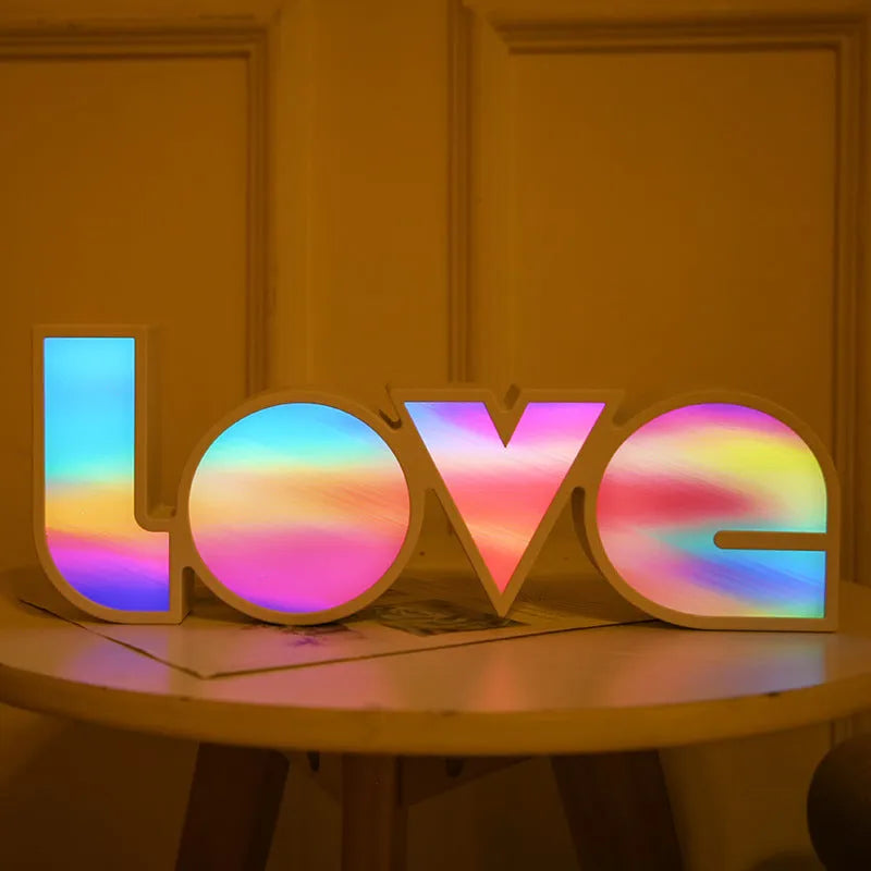LED LOVE light with rainbow shade measuring 35.5cm, glowing softly on a wooden desk for Valentine's decoration.