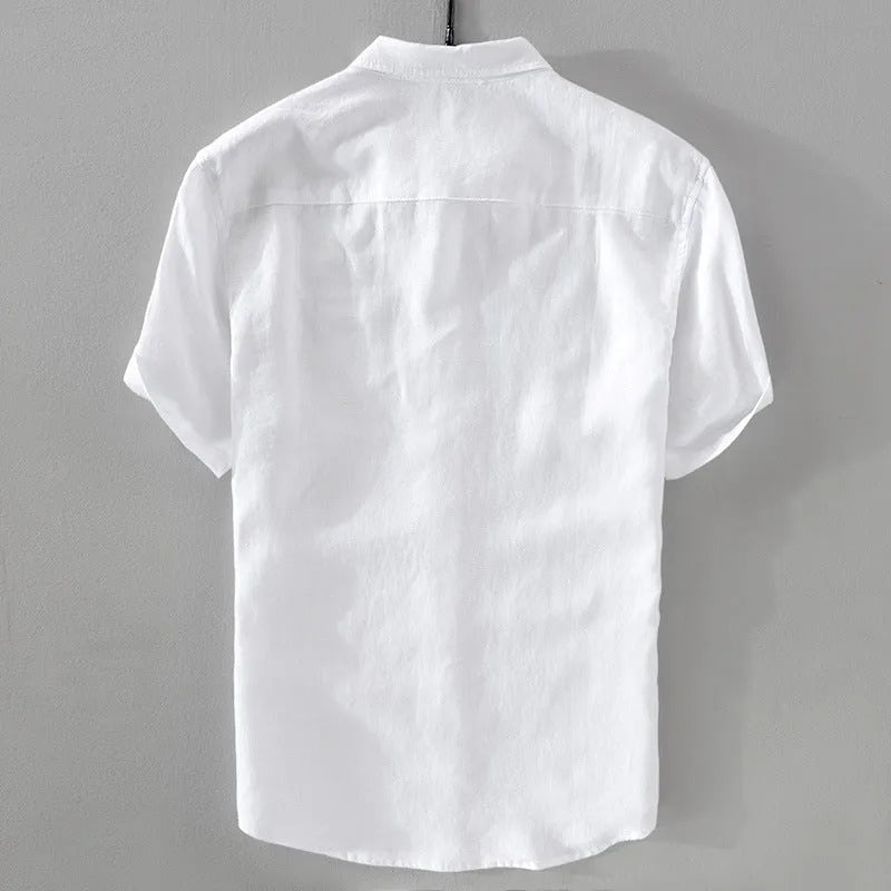 Man wearing a light blue loose fit short sleeve linen shirt for casual summer wear.