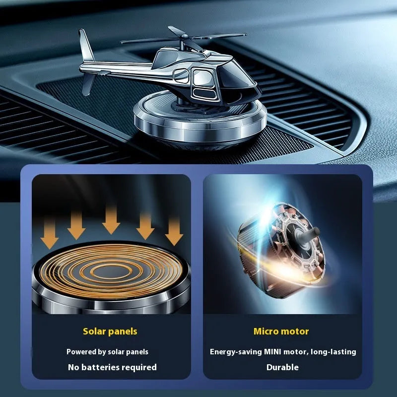 Silver metal solar-powered helicopter car air freshener ornament on a dashboard