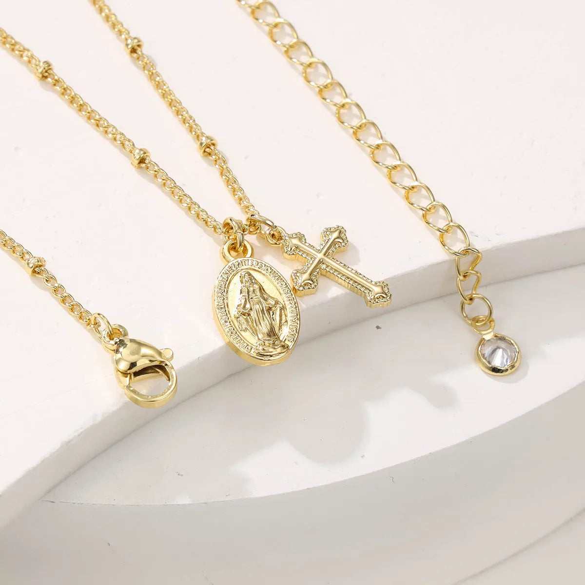 Gold geometric cross necklace with Virgin Mary ornament on chain