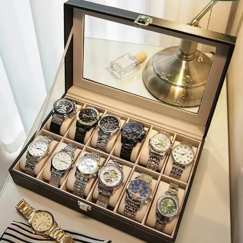 Grey leather watch storage box with transparent lid showing multiple watch slots inside.