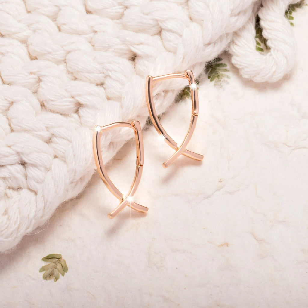 Rose gold coloured cross shaped drop earrings with contemporary light luxury styling