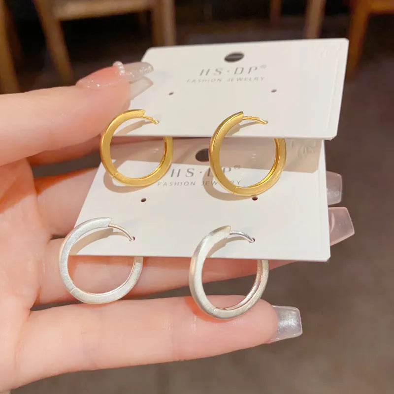 Women's geometric ear clip with round eyelet design in gold plating on copper