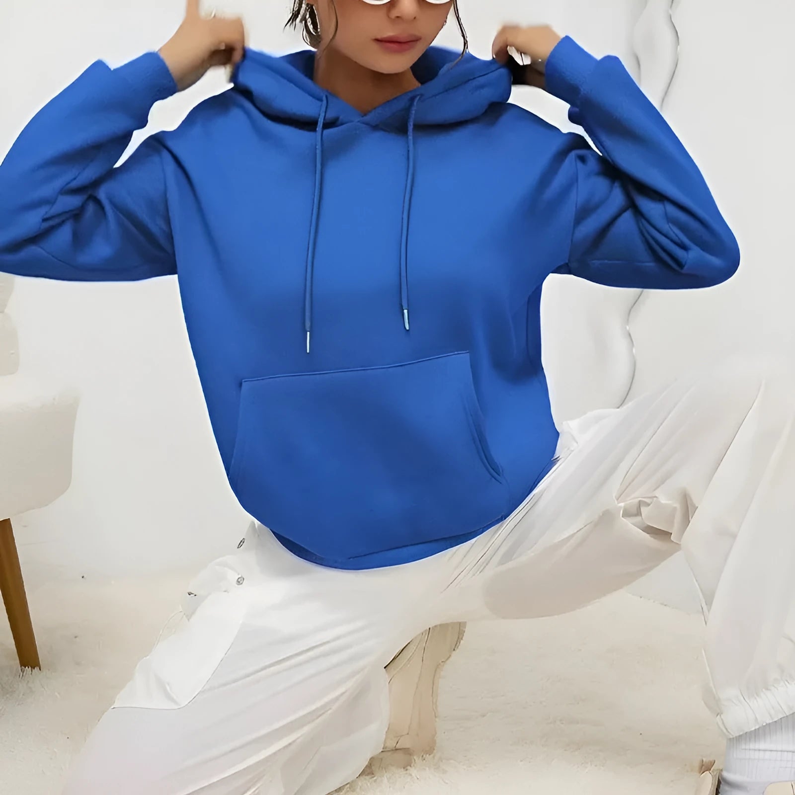 Women's loose grey drawstring hoodie with front pockets on a hanger.