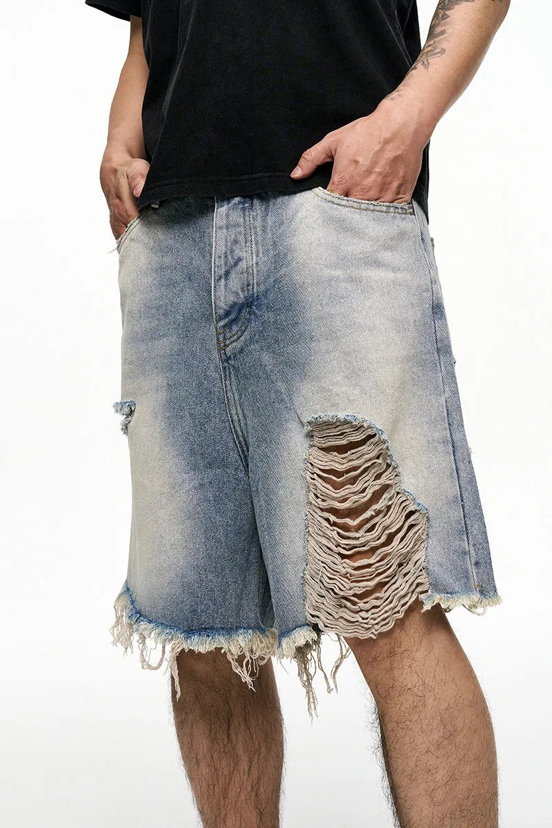 Men's light blue baggy denim shorts on a mid-waist mannequin, showing wide leg cut and zipper fly.