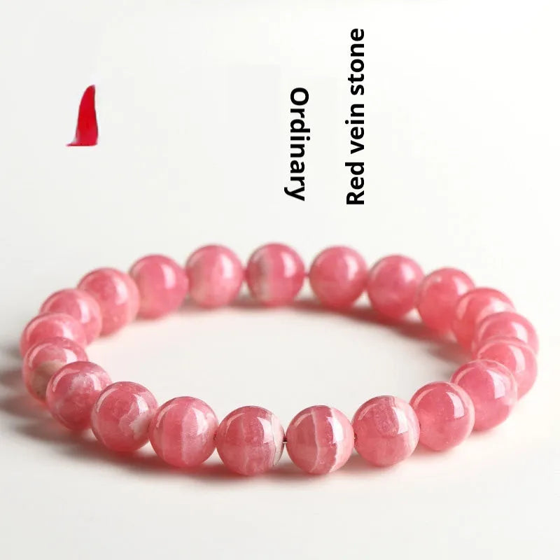 Women's geometric rhodochrosite crystal bracelet with a Longevity Lock design on red beads.
