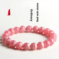 Women's geometric rhodochrosite crystal bracelet with a Longevity Lock design on red beads.