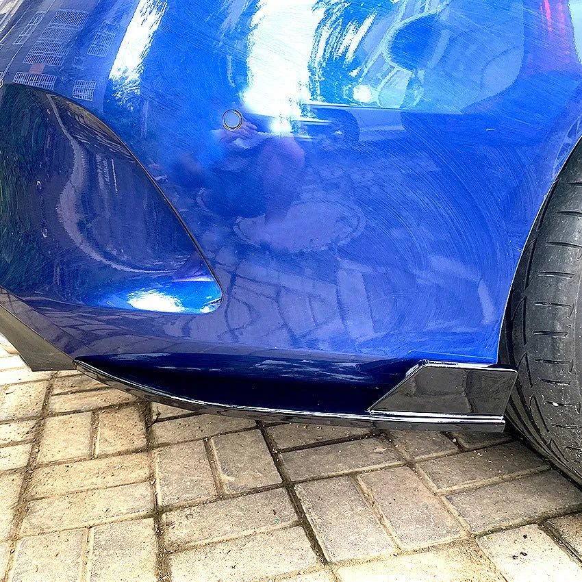 Pair of car rear bumper corner protectors in carbon fibre pattern on a vehicle rear corner