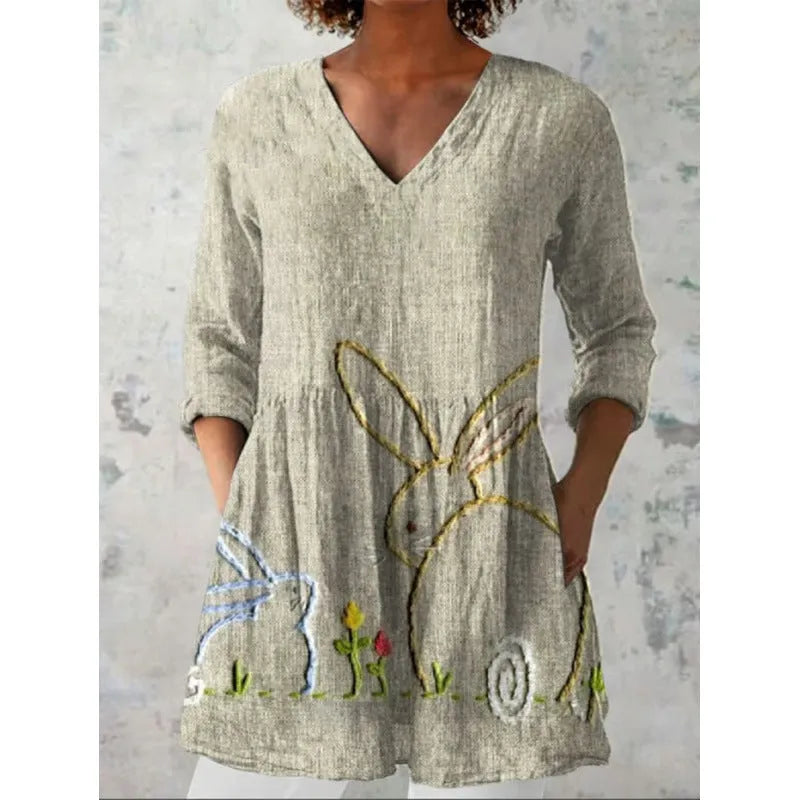 Women's printed loose-fitting dress with wide waist and three-quarter length sleeves.