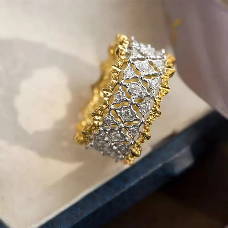Geometric two-tone gold copper ring with round zircon accents on a solid background.