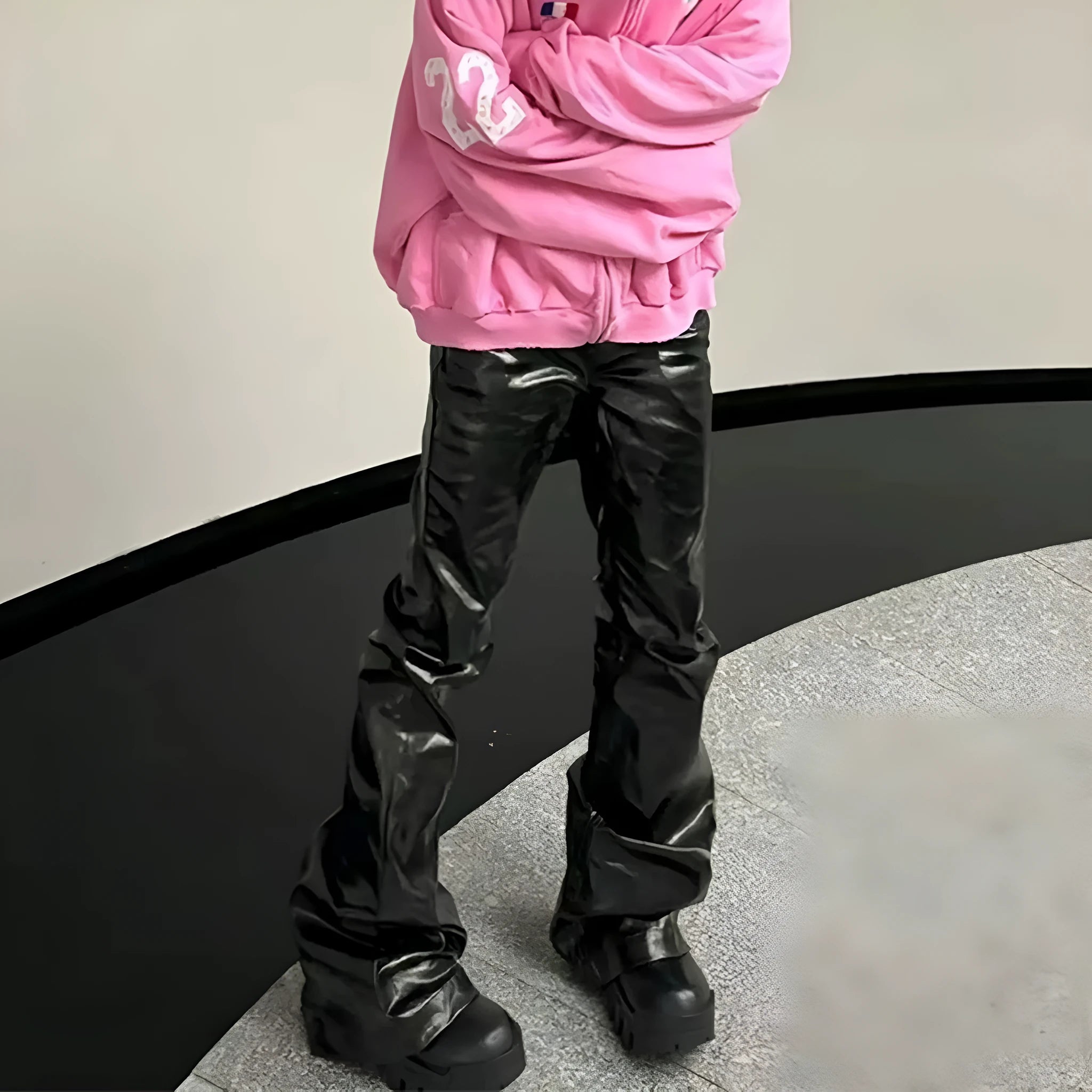 Black coated shiny patent leather straight leg skinny jeans on a hanger.