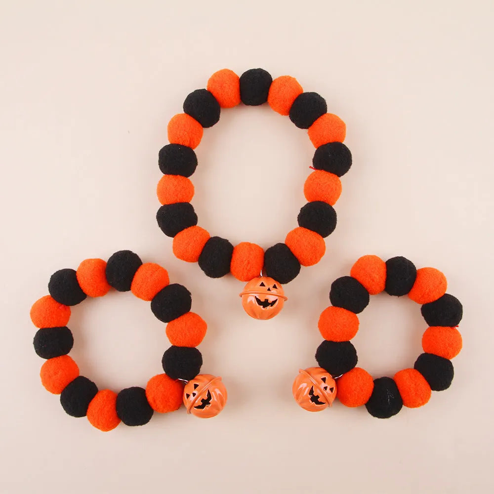 Orange Halloween cat collar with pumpkin print, breakaway buckle, and bell on a fabric band.