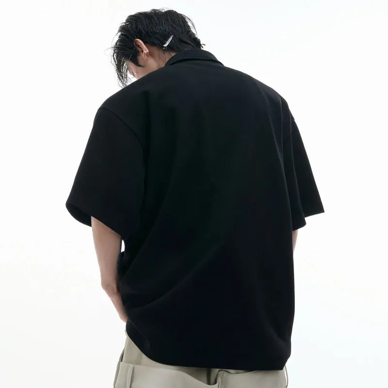 Men's black polo shirt with a deconstructed collar and a large geometric turtle graphic print on the front.