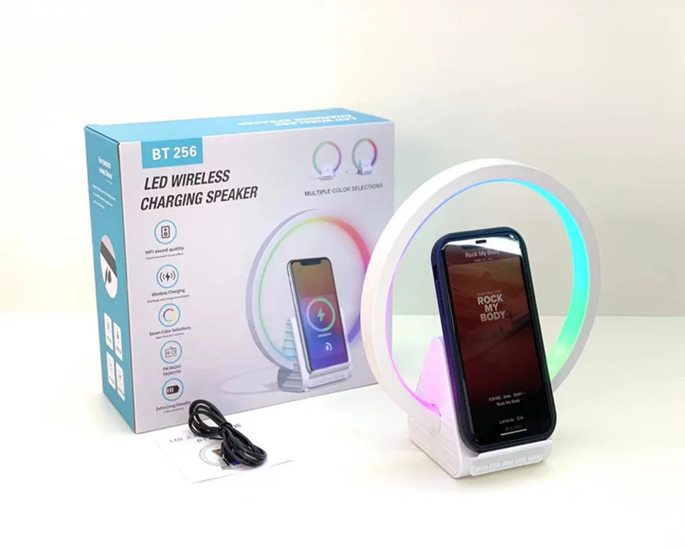 White portable Bluetooth speaker with integrated wireless charging pad and ambient lighting.