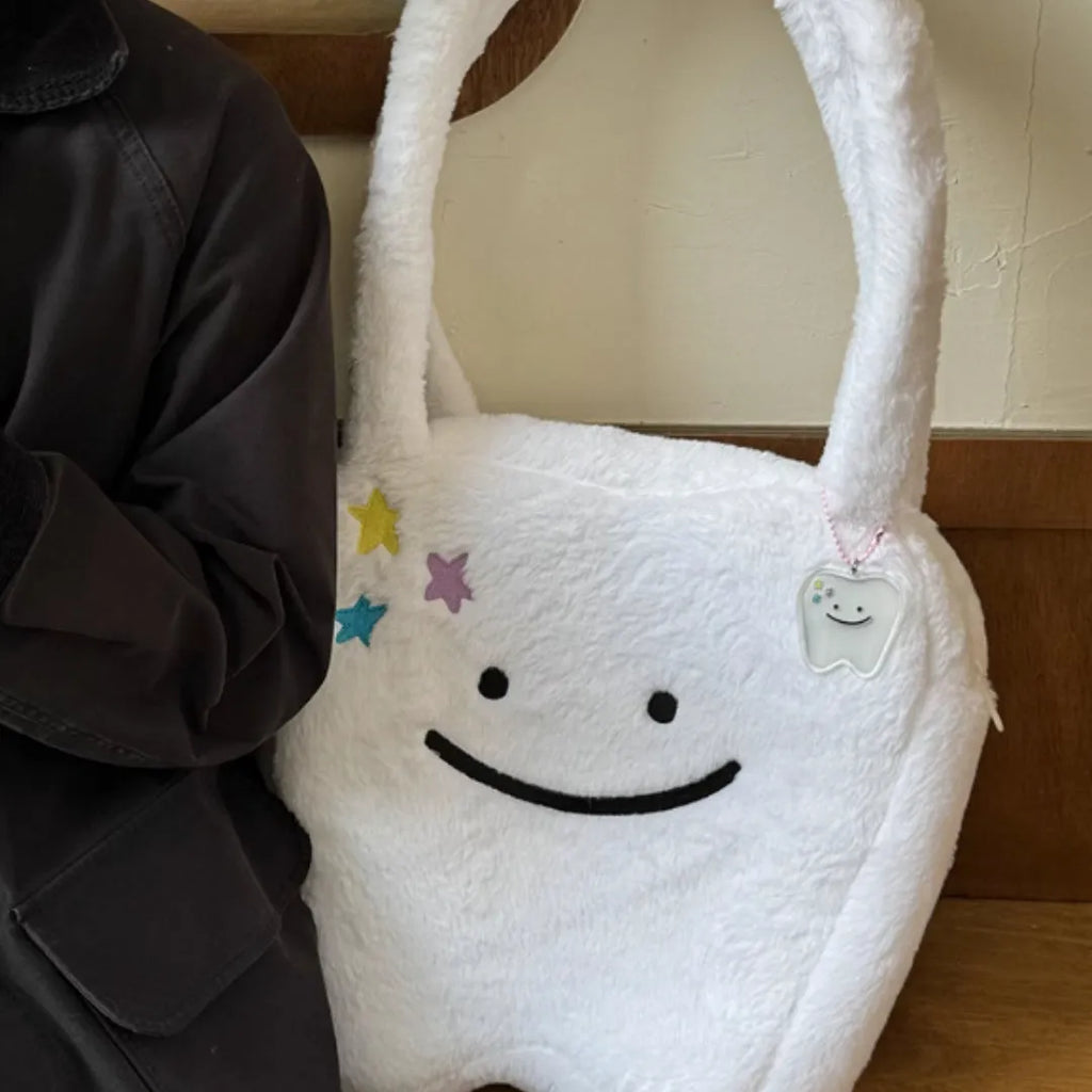 White large tote bag with plush large tooth shoulder strap and cute teeth design