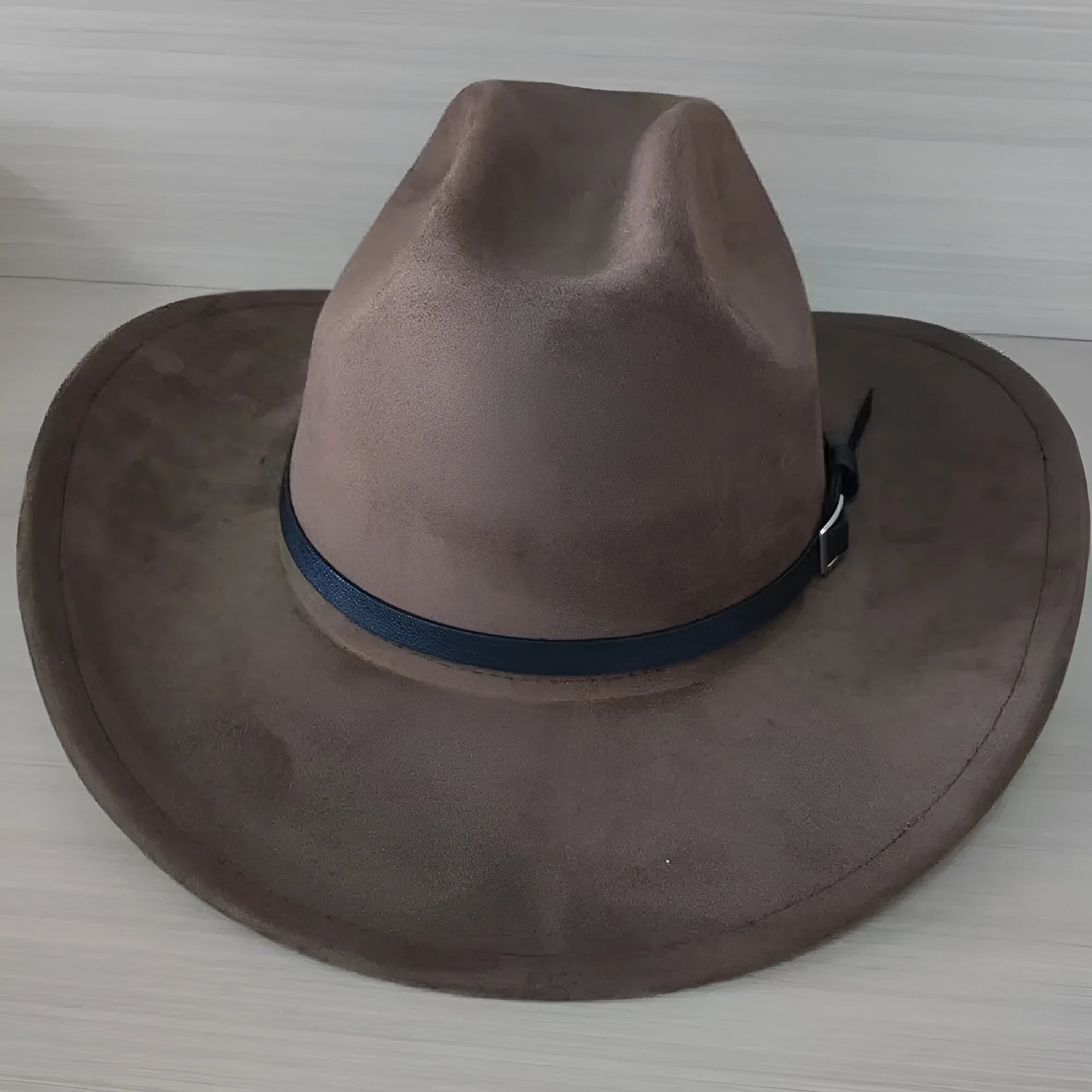 Brown leather velvet western cowboy hat with a curved brim and conical crown on a neutral background.