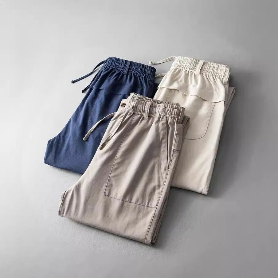 Man wearing solid-colour linen casual trousers in a relaxed setting.