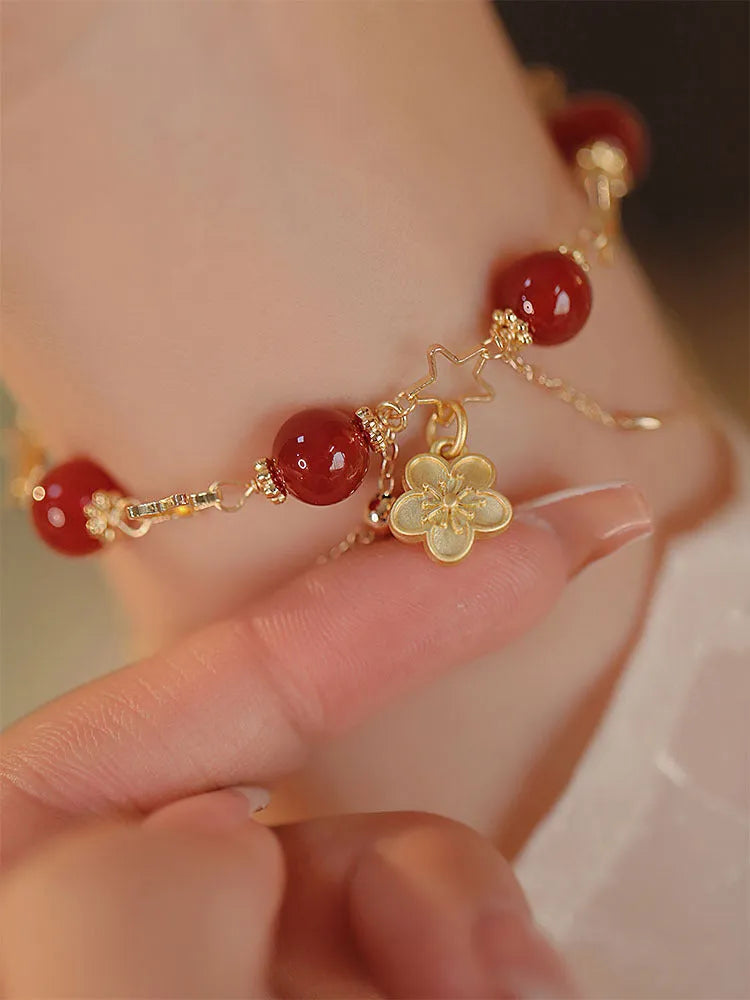 Close-up of natural red agate double layer bracelet with manual floral and peach blossom details for women.