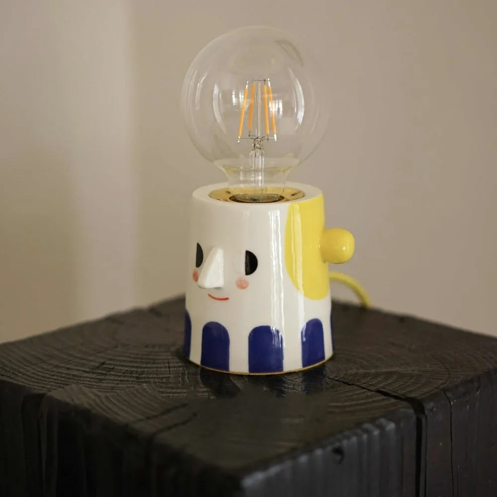 Handmade ceramic table lamp with a spherical ball headlight shape on a stand.