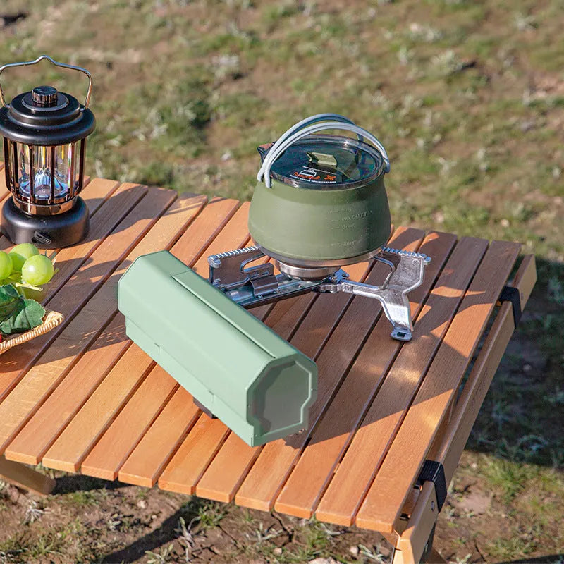 Green folding camping gas stove with storage bag showing compact 25cm size