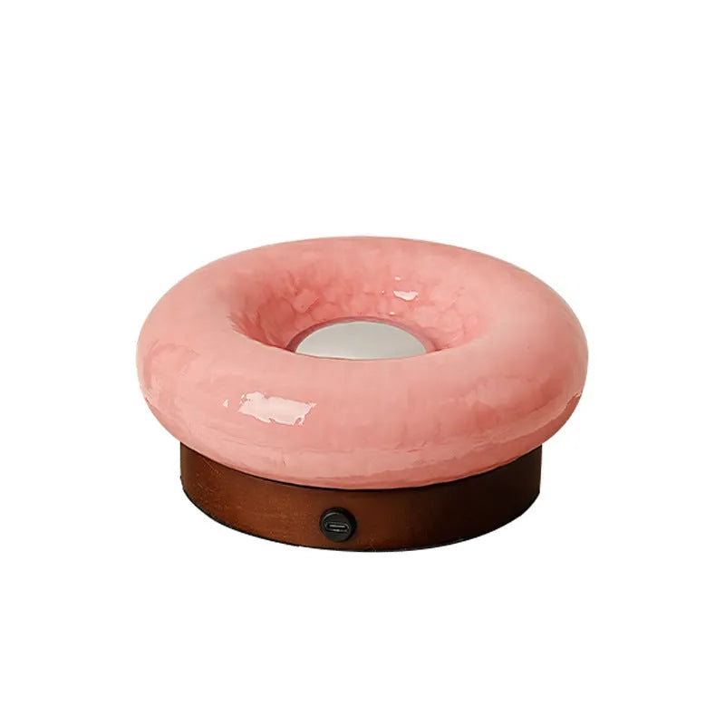 Donut-shaped touch table lamp in orange colour with three colour mode options on a desk