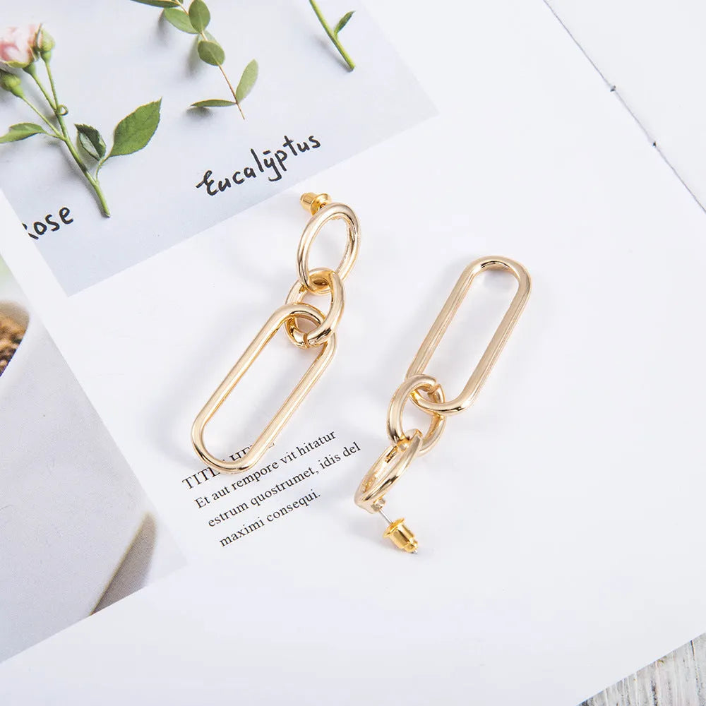 Geometric sterling silver needle hoop earrings with a line and ring design on a model.