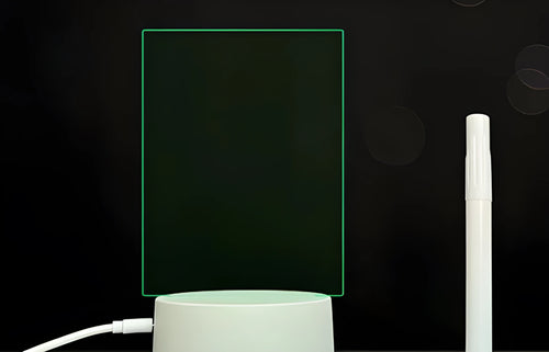 Black 3D acrylic LED night light and message board with stylus on a desktop