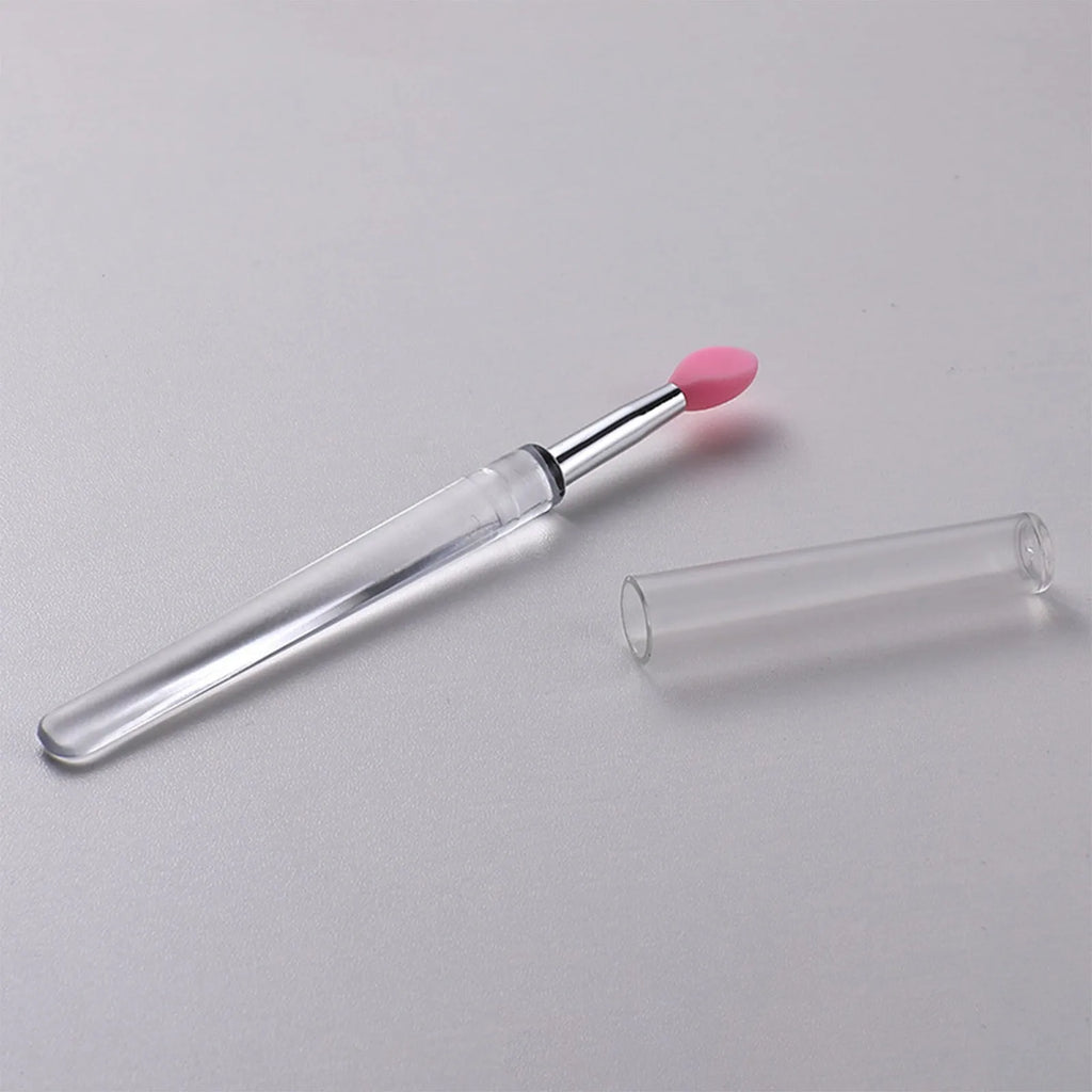 Set of reusable silicone lip brushes with protective caps in various colours on a pink background.