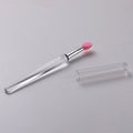 Set of reusable silicone lip brushes with protective caps in various colours on a pink background.