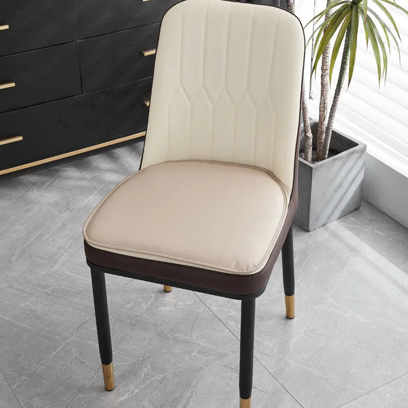 Orange leather horseshoe-shaped seat cushion on a wooden chair showing non-slip base.
