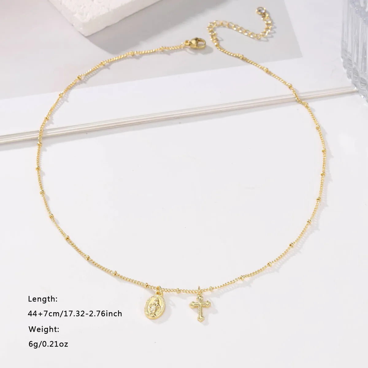 Gold geometric cross necklace with Virgin Mary ornament on chain
