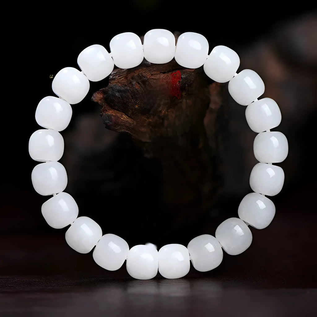 White Hetian jade barrel bead bracelet on a wrist, showing smooth beads in a unisex casual style.