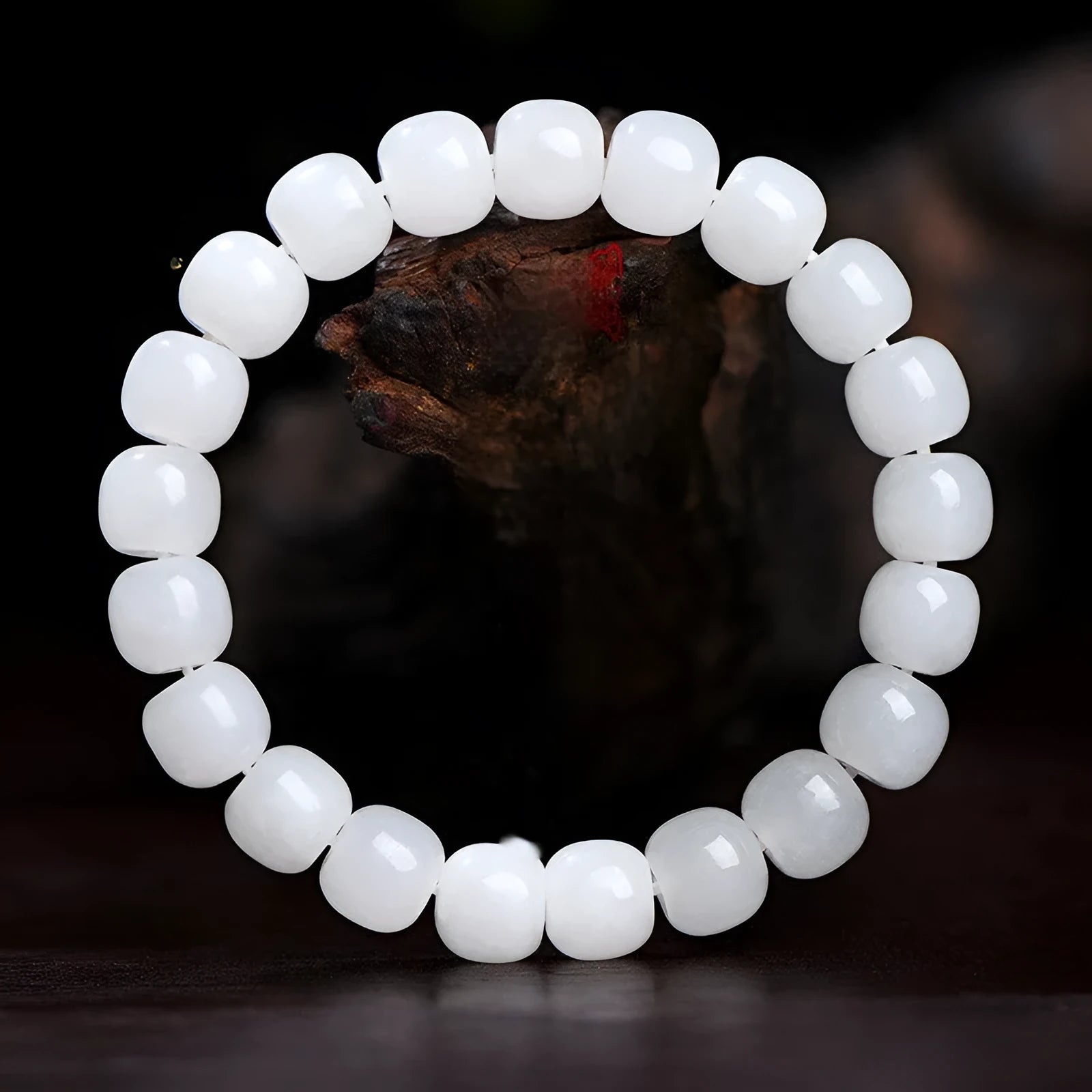 White Hetian jade barrel bead bracelet on a wrist, showing smooth beads in a unisex casual style.