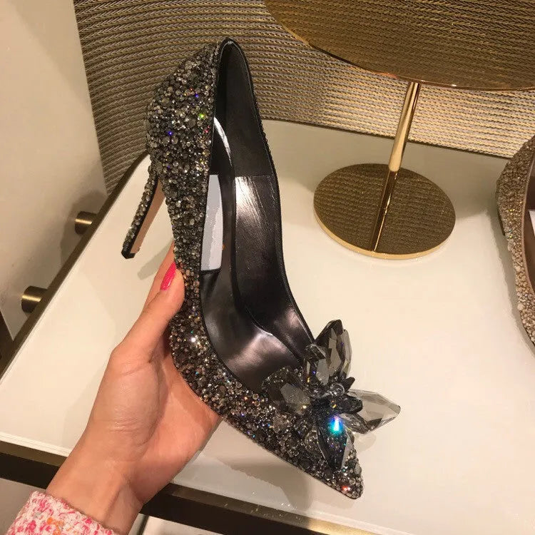 Gold women's pointed toe high heels with rhinestone and bow decoration on a stiletto heel.