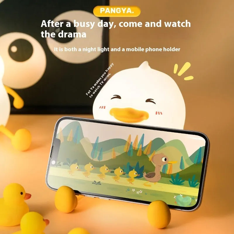 Chubby silicone night light with LED glow functioning as a desktop phone holder