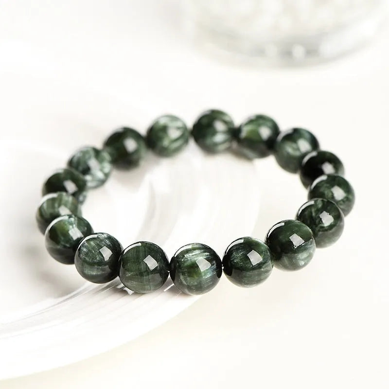 Green Dragon Crystal bracelet with round beads and a central Ruyi knot on a wrist.
