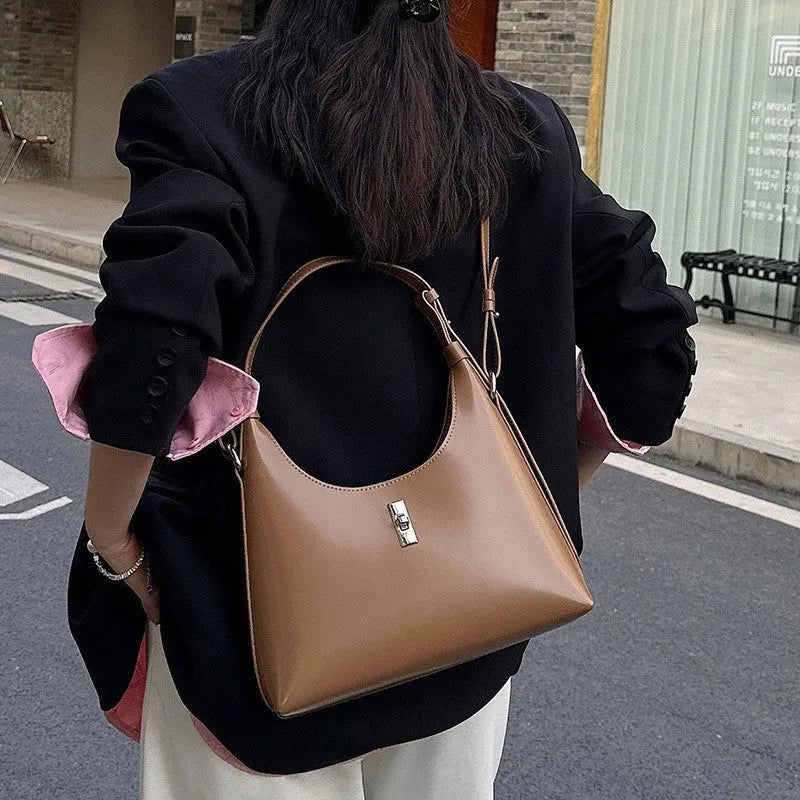 Soft genuine leather crossbody shoulder bag in dumpling shape with internal phone pocket and change compartment