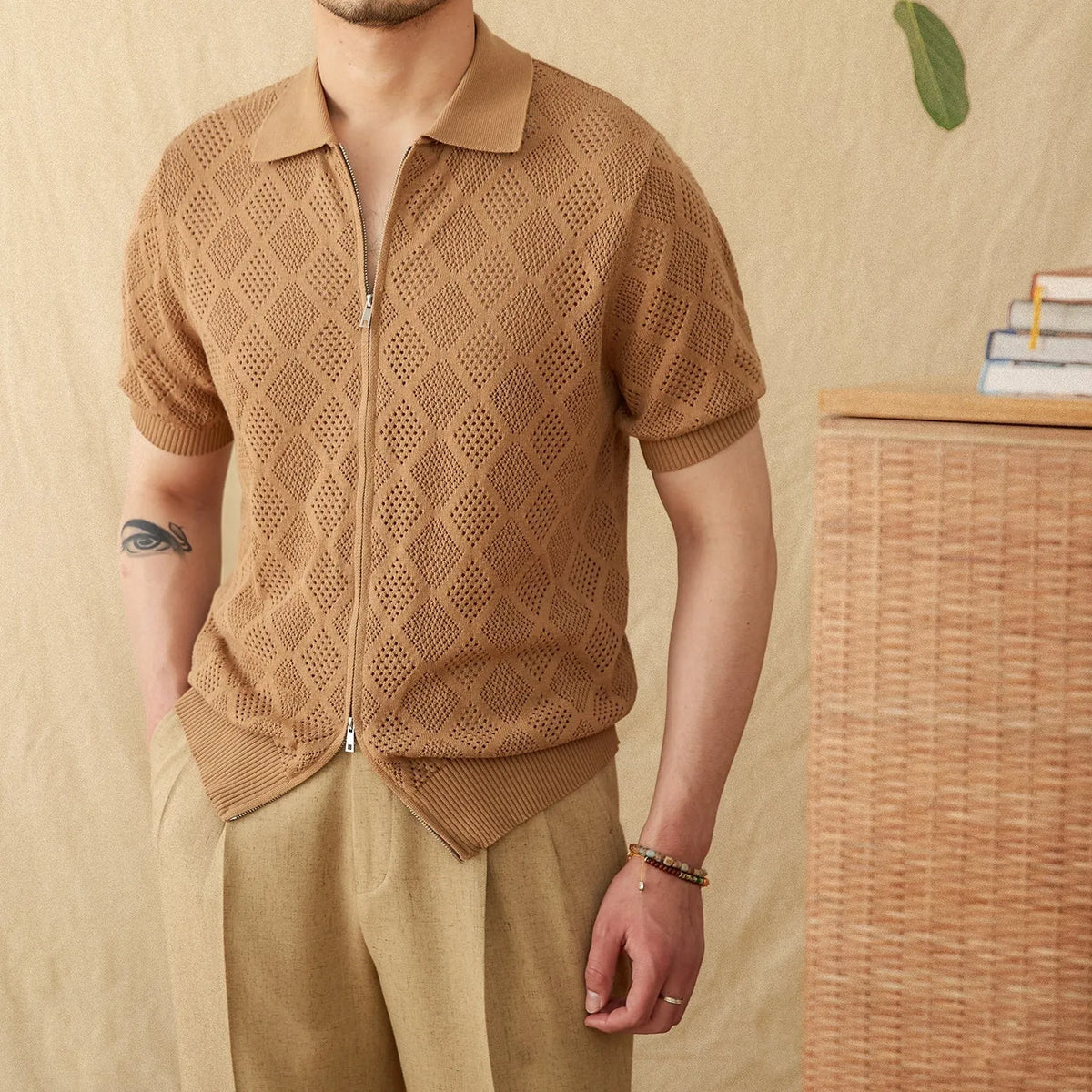 Light brown cotton cardigan top with lapel collar, short sleeves, and a centre front zipper on a hanger.
