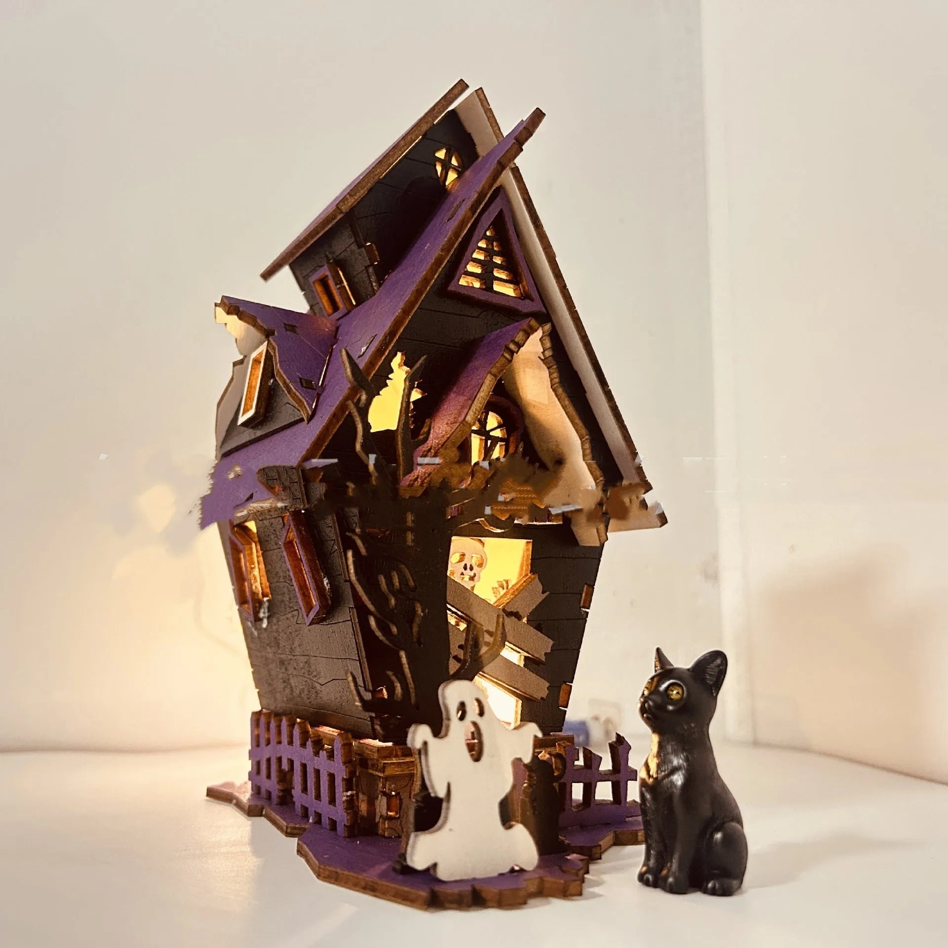 Wooden glowing haunted house Halloween table decoration with candlestick holder function.