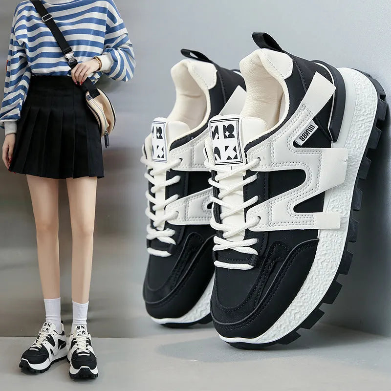 Low top unisex running sneaker in black or white with round toe and flat rubber sole.