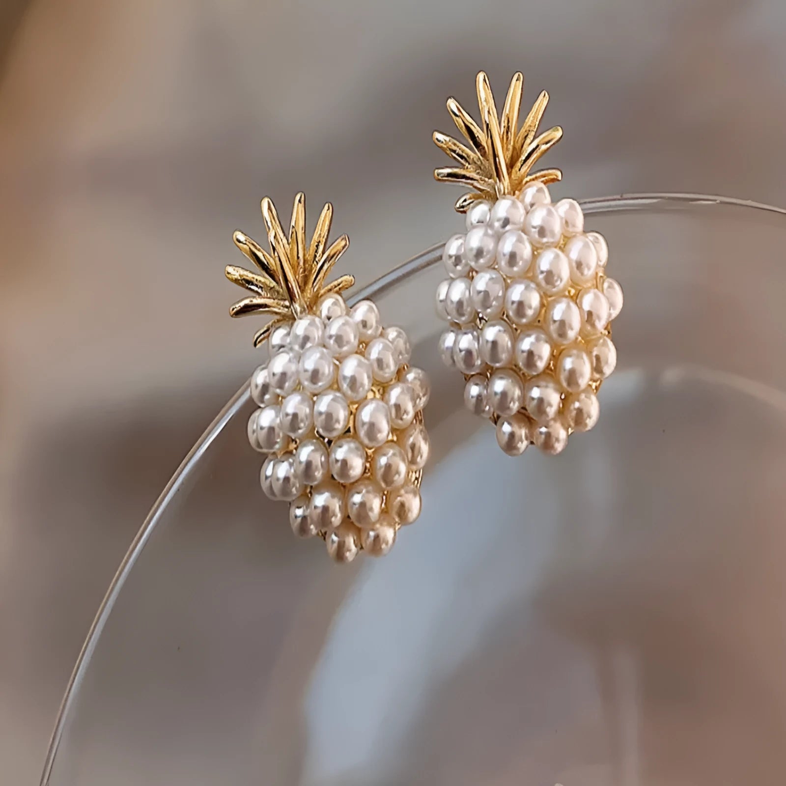 Korean-style pineapple starfish pearl earrings in electroplated alloy with decorative gemstones.