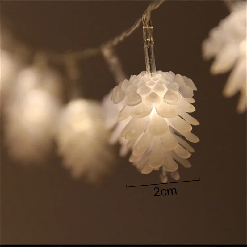 Warm white LED pine cone light string powered by AA batteries, shown in a 10-light or 20-light option for decorative use.