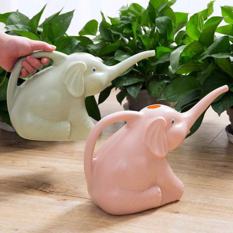 Pink children's watering can shaped like a sitting baby elephant with a long spout and bottle-shaped handle.