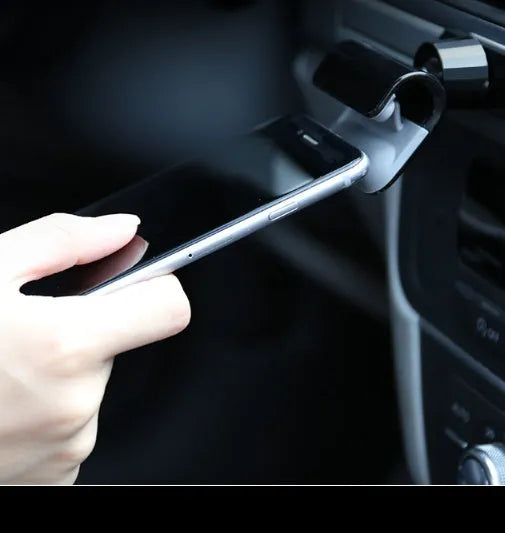 Black gravity car phone holder mounted on a car air vent, showing 360-degree rotation and universal phone grip.