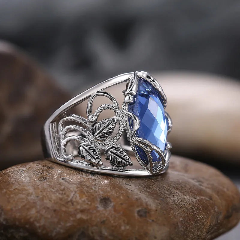 Women's horse eye-shaped blue crystal alloy ring on a hand, showing geometric design.
