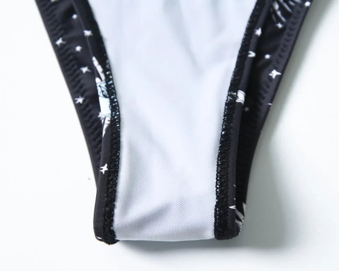 Black printed one-piece swimsuit with a backless design for women.